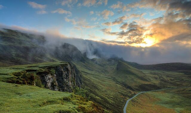 photo d'un paysage verdoyant avec une route sinuant dans la vallée